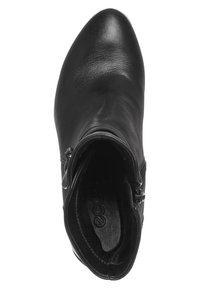 Bottine en cuir noir avec fermeture éclair latérale, bout pointu arrondi et intérieur rembourré visible de dessus.