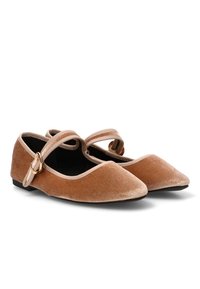 Bailarinas de terciopelo en marrón claro con puntera puntiaguda y dobles correas en el tobillo. Presenta herrajes en tono dorado y un interior negro. Suela plana.