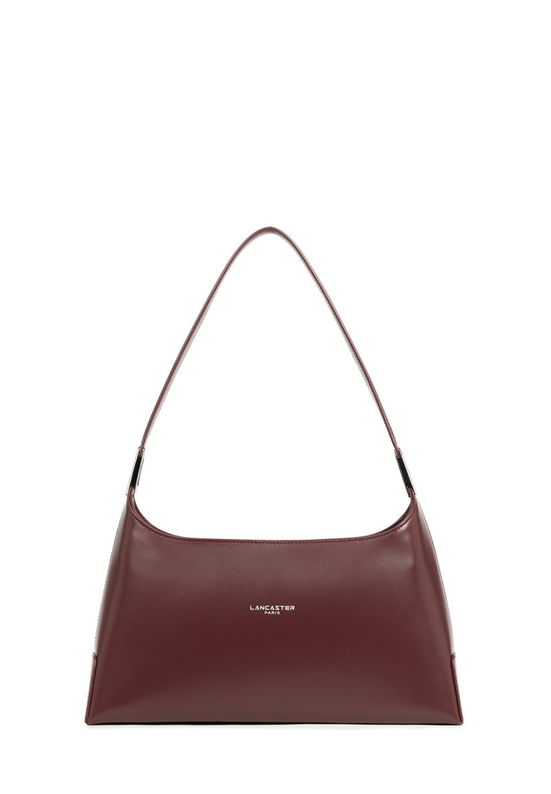 Sac à bandoulière en cuir bordeaux au design épuré et incurvé, avec une seule sangle. Présente un détail logo en argent sur le devant. Texture lisse.