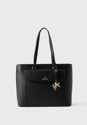 Sac cabas noir structuré avec de longues anses pour l’épaule, une poche avant à rabat et un charm doré en forme de lettre.