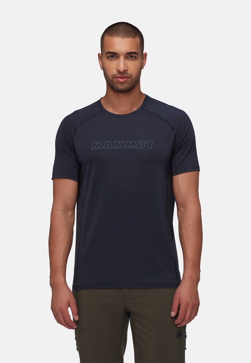 Marinblå kortärmad skjorta av lätt material, med en texturerad logotyp "MAMMUT" fram och en figurnära design.