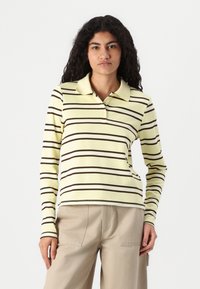 Poloshirt met lange mouwen in pale geel met bruine horizontale strepen, voorzien van een kraag en knoopdetails. Gestructureerde stof.