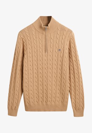 Beige Kabelstrickpullover mit hohem Kragen und halben Reißverschluss. Verfügt über gerippte Bündchen und Saum sowie ein kleines Logo auf der Brust.