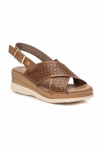 Sandalia de cuero marrón con diseño floral perforado, correa ajustable en el tobillo, suela de cuña ligera y plantilla acolchada.