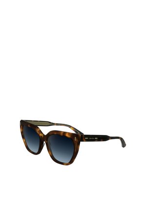 Occhiali da sole tortoiseshell marroni con una grande montatura a occhio di gatto, lenti blu sfumate e accenti dorati sulle tempie. Logo del marchio visibile sul lato.
