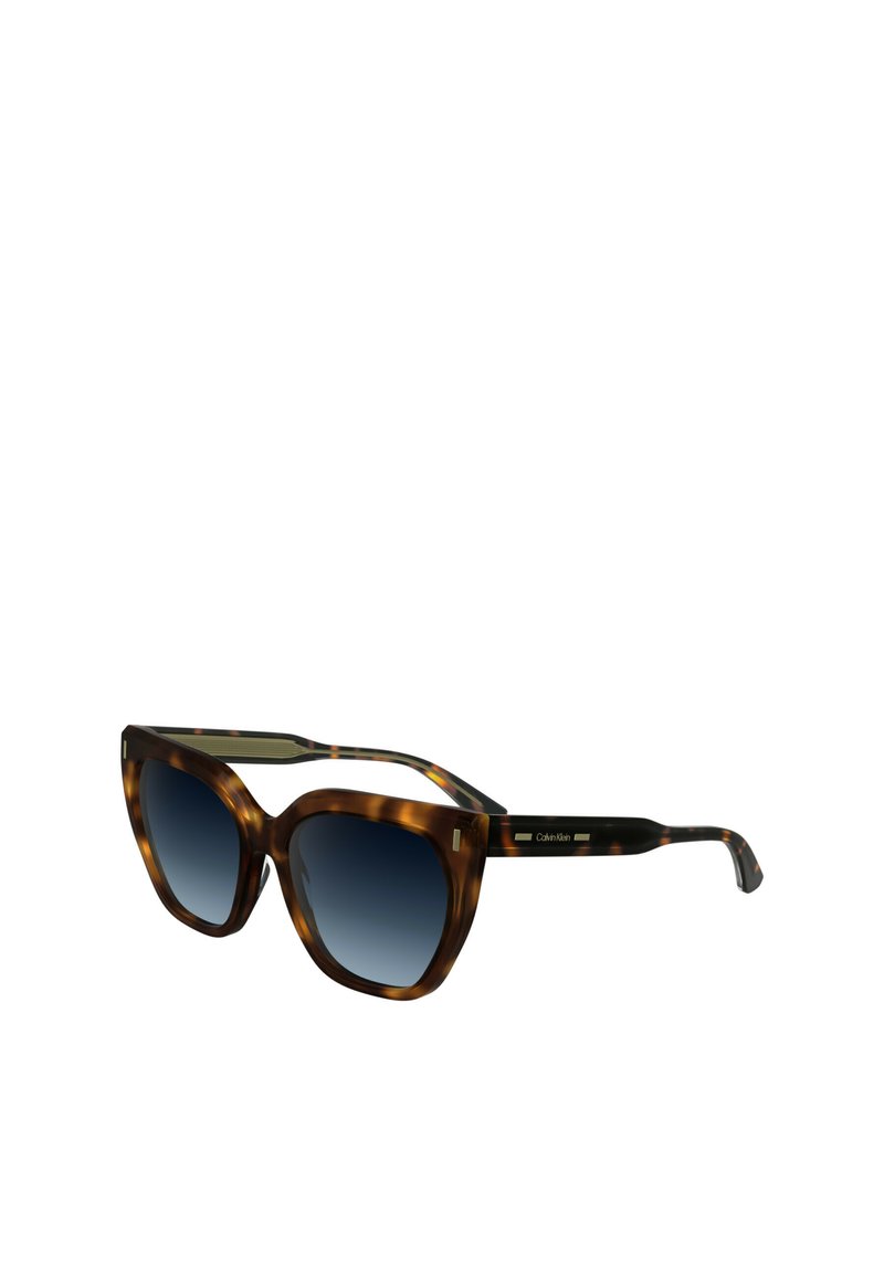 Occhiali da sole tortoiseshell marroni con una grande montatura a occhio di gatto, lenti blu sfumate e accenti dorati sulle tempie. Logo del marchio visibile sul lato.