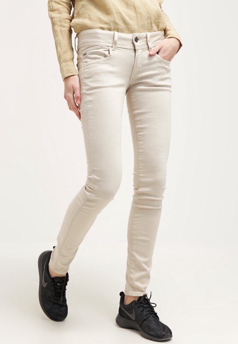 Béžové skinny džíny vyrobené z bavlněné směsi, s klasickým pětikapesním designem, zapínáním na knoflík a mírným elastanem pro pohodlí.