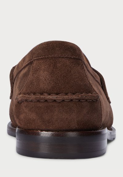 Smeđe sued loaferice s glatkom završnom obradom, šivanim detaljima duž gornjeg dijela i tamnom drvenom potplatu za dodatni kontrast.