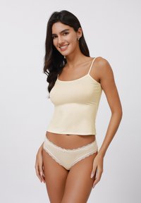 Light yellow tank top with thin straps, paired with matching panties featuring lace trim. Smooth fabric with a fitted silhouette.