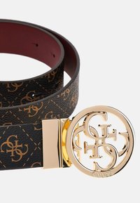 Schwarzer Ledergürtel mit einer goldenen runden Schnalle mit einem verschlungenen Logo und einer strukturierten Oberfläche mit geprägten braunen Symbolen.
