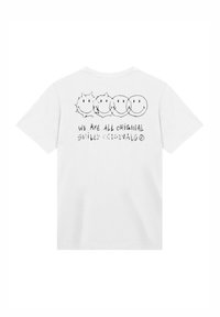 White cotton t-shirt featuring black printed cartoon smiley faces and text that reads "WE ARE ALL ORIGINAL SMILEY ORIGINALS."