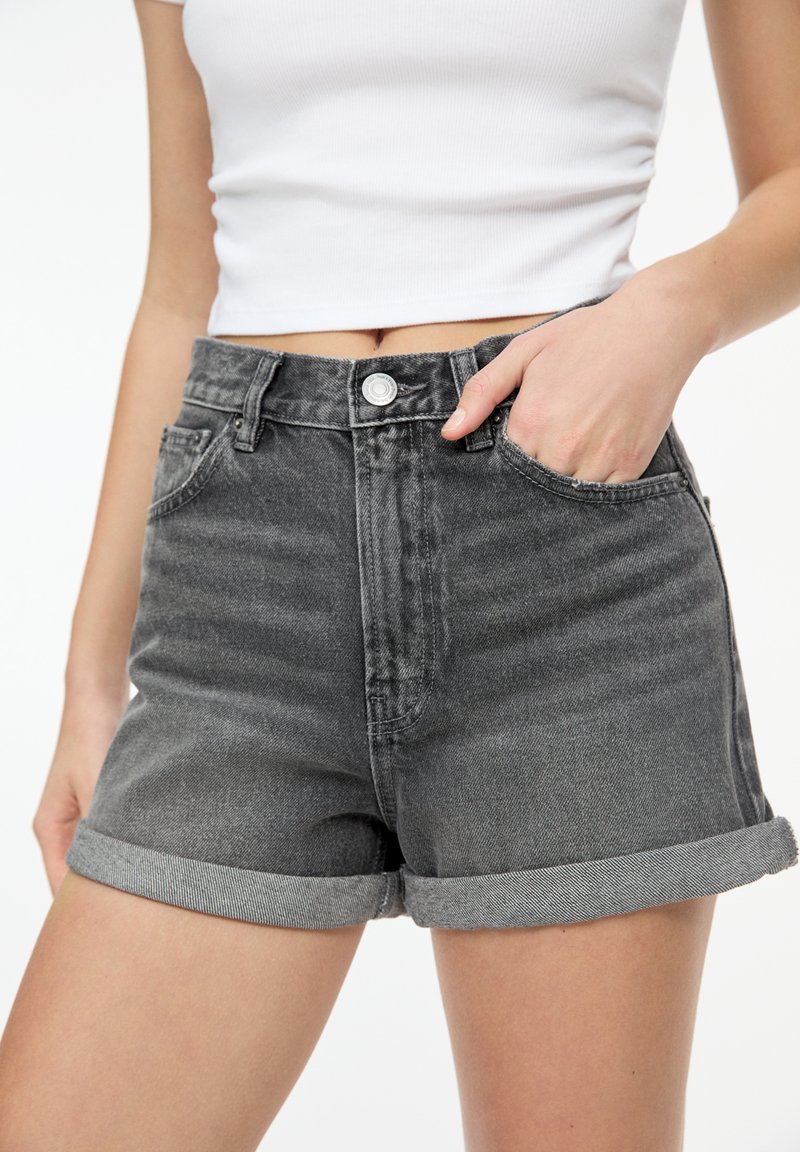 Gray denim shorts with a high waist, rolled cuffs, five pockets, and a front metal button closure. Smooth texture with light fading.