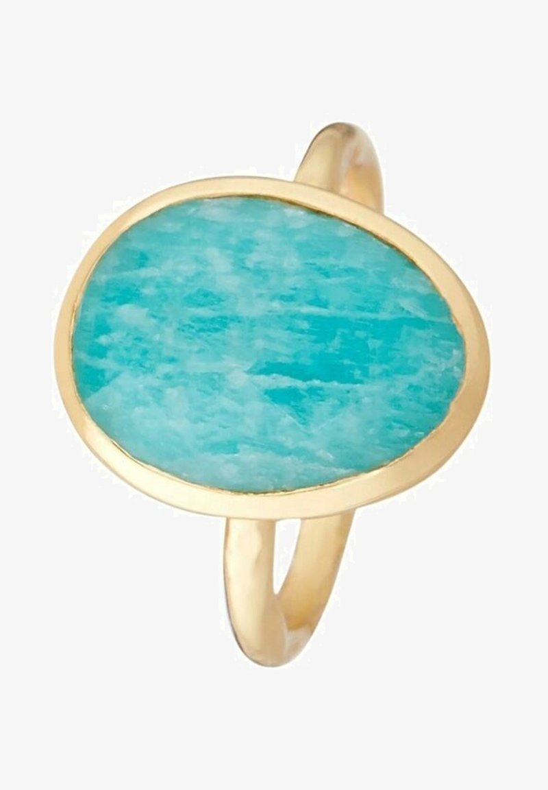 Bague en or avec une pierre turquoise ovale irrégulière sertie dans un simple chaton, montrant la texture naturelle de la pierre et ses variations de couleur.
