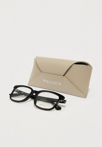 Óculos retangulares pretos com lentes transparentes, acompanhados de uma bolsa de couro bege com fecho de aba e logotipo em relevo.
