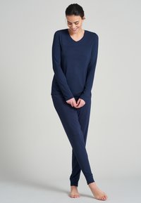 Mörkblå långärmad pyjamatröja med V-hals, matchande smalbyxor i mjukt och lätt tyg.