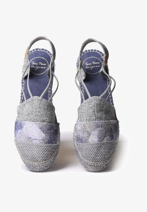 Sive espadrile z z woven teksturo, ki imajo cvetlični vzorec na predelu prstov in križno zavezane trakove za varen oprijem. Modra notranja obloga.