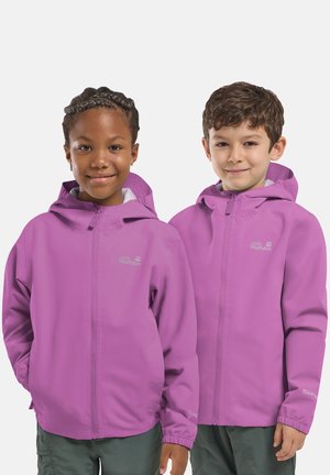 Due bambini con giacche viola con cappuccio abbinate stanno uno accanto all'altro, sorridendo leggermente su uno sfondo neutro.