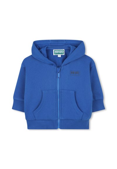 Haut à capuche zippé bleu avec un design à deux poches à l'avant, des poignets côtelés et un logo brodé. Fabriqué dans un matériau doux et lisse.