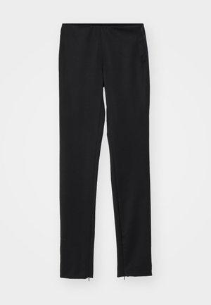 Czarne, dopasowane spodnie z elastycznym pasem, gładką fakturą i zamkami błyskawicznymi u dołu. Wykonane z lekkiego materiału.