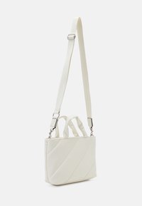 Borsa bianca con motivo a rombi diagonali, dotata di doppi manici superiori e di una tracolla staccabile e regolabile. Realizzata in materiale sintetico liscio.
