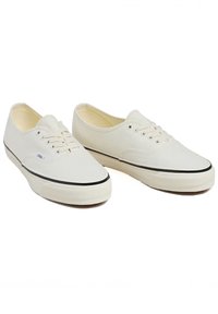 Leinen-Sneaker in Off-White mit Schnürdesign, schwarzer Gummisohle und kontrastierendem schwarzen Rand entlang der Kante.