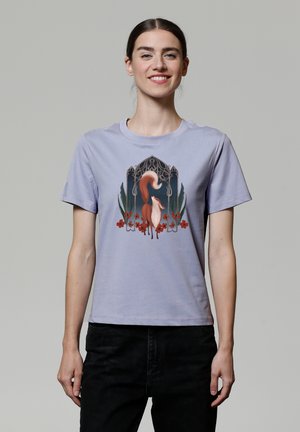 Lila katoenen T-shirt met een grafisch ontwerp van een vos omringd door rode bloemen en groene bladeren, met ingewikkelde designelementen erboven.