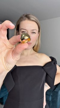 Gold and black ring with a smooth, curved design. The interior is gold-toned, contrasting with the dark exterior finish.