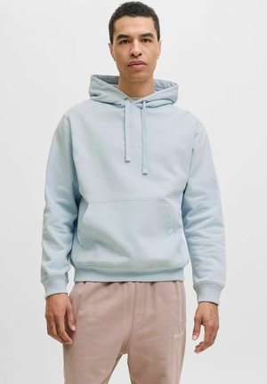 Lys blå bomulds hættejakke med en lomme foran, snore i hætten og ribbet kant. Båret med lyserøde sweatpants med et logo.