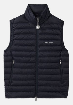 Marineblauwe gewatteerde vest met hoge kraag, voorrits, twee ritszakken en logo-detail aan de linkerkant. Genestelde, gevoerde textuur overal.
