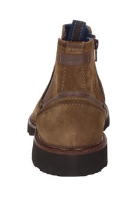 Bottines en daim marron à fermeture éclair arrière, avec des accents en cuir marron et une semelle en caoutchouc texturé. Comprend une boucle pour un enfilage facile.
