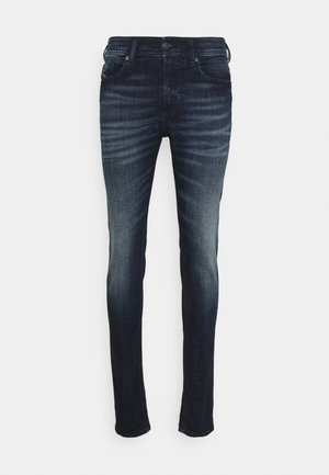Jean slim bleu foncé avec des détails délavés sur les cuisses et les genoux, bouton à l'avant, fermeture éclair et design cinq poches.