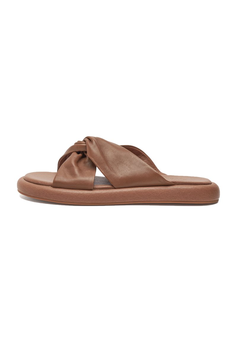 Brown leather slide sandal with knotted strap design, cushioned footbed, and a thick rubber sole. Smooth texture and minimalist style.