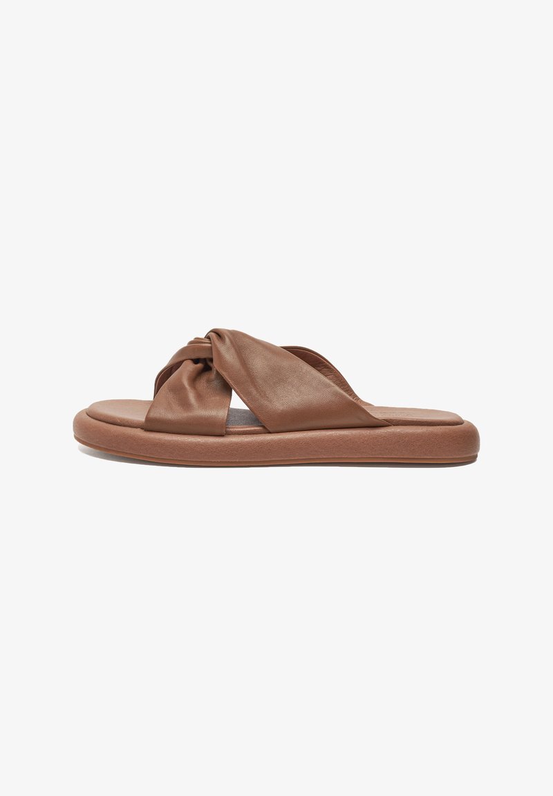 Brown leather slide sandal with knotted strap design, cushioned footbed, and a thick rubber sole. Smooth texture and minimalist style.