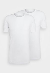 Deux t-shirts blancs simples sont exposés. Ils ont des manches courtes et un col ras du cou, fabriqués dans un tissu lisse et léger.