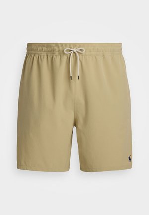 Bežové plavkové šortky s elastickým pásom, sťahovacou šnúrkou a malým námorníckym logom na dolnej ľavej strane.