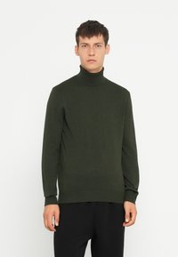 Pulover de culoare verde închis, cu guler înalt, confecționat dintr-un material tricotat moale, având mâneci lungi și manșete cu dungi, cu o siluetă ajustată.