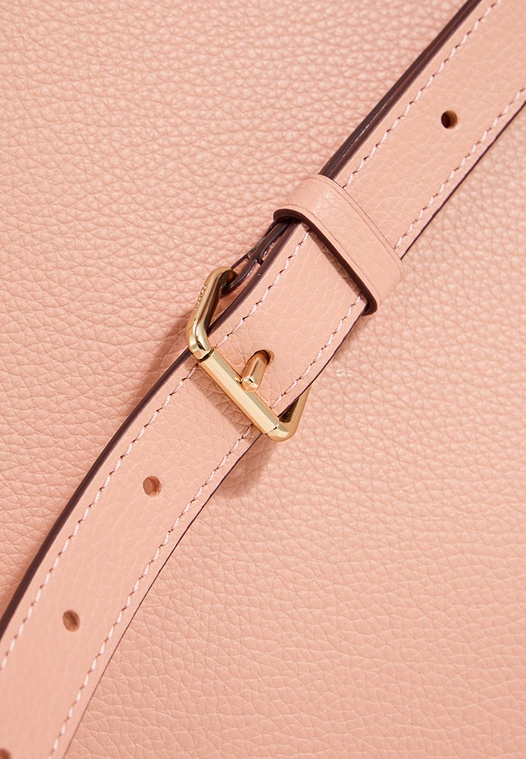 Rosa läderrem med ett guldmetallspänne, som har en texturerad yta och en tunn, jämn kant. Remmen har flera justeringshål.