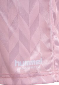 Jasnoróżowa tkanina sportowa z geometrycznym wzorem w zygzaki. Logo "hummel sportwear" jest wyraźnie wyeksponowane na białym tle.