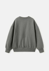 Felpa grigia con texture morbida, collo rotondo e polsini elastici. Vestibilità rilassata con banda elastica a coste in vita, caratterizzata da un colore uniforme senza motivi.