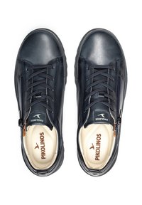 Baskets en cuir bleu marine foncé avec fermeture à lacets et zip latéral, dotées d'une semelle intérieure crème et d'un logo "Pikolinos" marron sur la languette.
