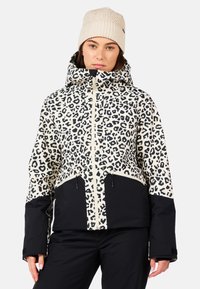 Kurtka ocieplana w print w panterę na czarnym tle, z kontrastowymi suwakami i kapturem. Posiada zamek błyskawiczny z przodu, regulowane sznurki oraz ciepłą dzianinową czapkę.