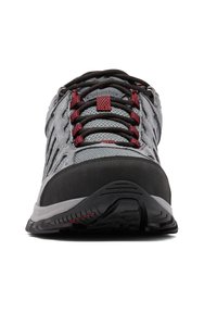 Szary but turystyczny z teksturowaną cholewką z siateczki, czarnym gumowym noskiem, czerwonymi akcentami oraz amortyzowaną podeszwą z wzorzystym bieżnikiem.