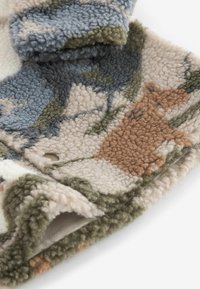 Tissu polaire doux avec un motif camouflage dans des tons bleu, vert, beige et marron, montrant une texture et des coutures détaillées.