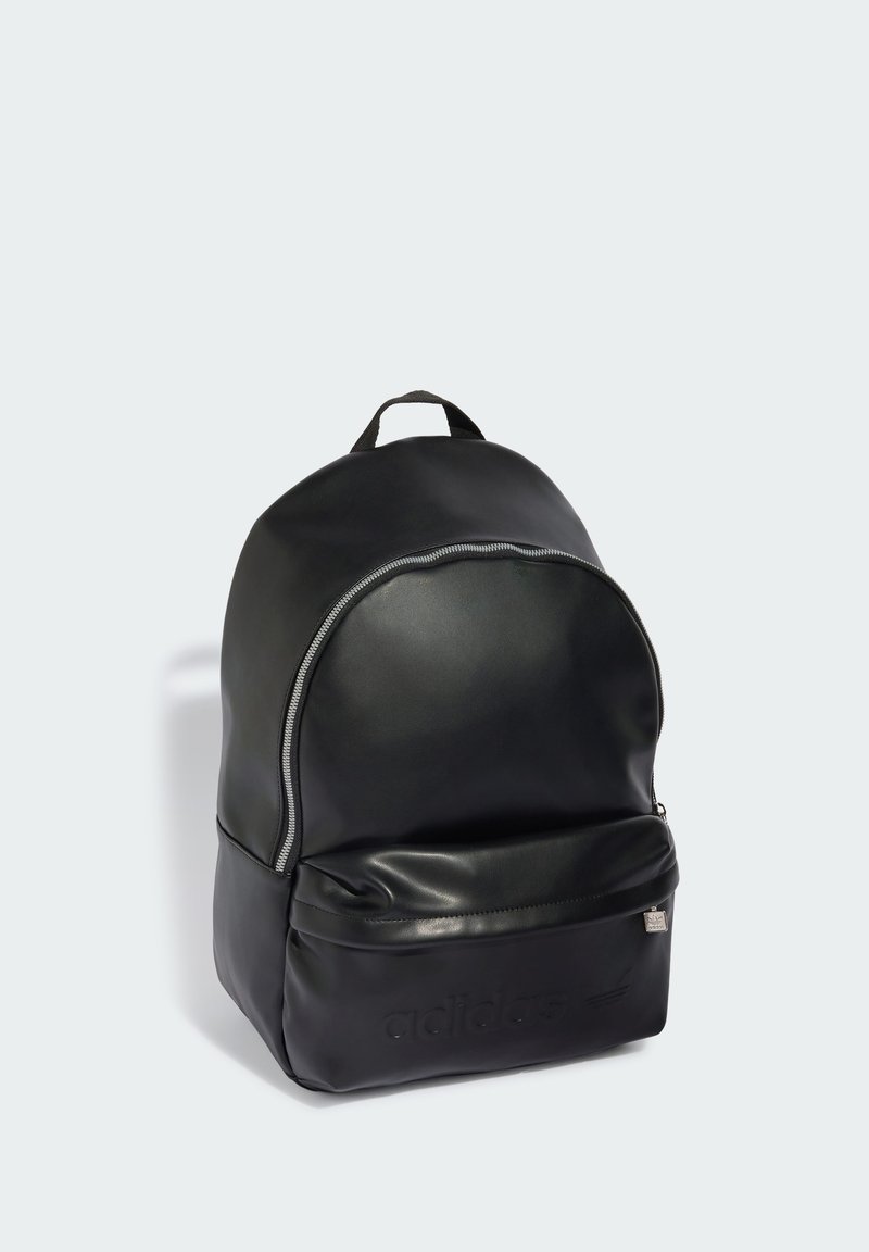 Zaino Adidas in pelle nera con una tasca frontale con cerniera e una maniglia superiore, mostrato su uno sfondo grigio chiaro.