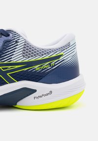 Modrá sportovní bota s síťovaným svrškem, kontrastními bílými a žlutými akcenty a texturovanou podrážkou. Obsahuje branding "Beyond FF" a technologii FlyteFoam.