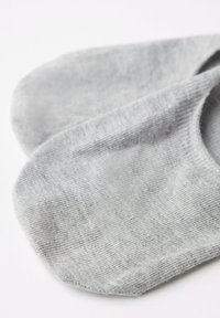 Calcetines grises para los tobillos hechos de material suave y texturizado. Diseño sin costuras con un sutil patrón acanalado en los bordes. Forma de puntera redondeada.