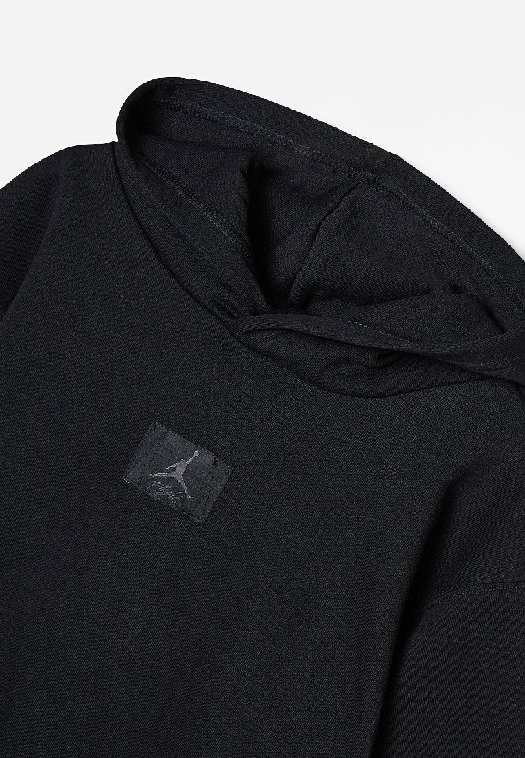 Czarna bluza z kapturem wykonana z miękkiego materiału. Posiada naszywkę z logo przedstawiającą skaczącą postać. Projekt zawiera kaptur ze sznurkiem do regulacji oraz ściągacze przy mankietach.