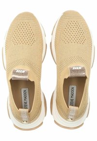 Beige Strick-Sneaker mit strukturiertem Obermaterial, weißer Mittelsohle und Gummilaufsohle. Verfügt über eine markierte Zuglasche und ein inneres Etikett.