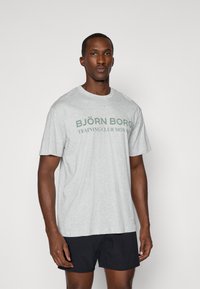 Svetlošedé bavlnené tričko s zeleným logom „BJ�ÖRN BORG TRAINING CLUB MONACO“ na prednej strane, s voľným strihom a okrúhlym výstrihom.