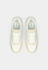 Λευκά δερμάτινα αθλητικά παπούτσια με μπεζ λεπτομέρειες, στρογγυλή μύτη, διακοσμητικές διάτρητες λεπτομέρειες και λευκά επίπεδα κορδόνια. Μαλακή επένδυση και μαξιλαρωμένη σόλα.